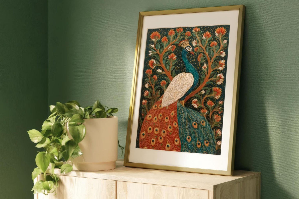 a framed painting of a peacock, with a vibrant and intricate design of flowers and foliage surrounding the bird. The painting is displayed on a wooden surface, with a potted plant to the left of the frame.