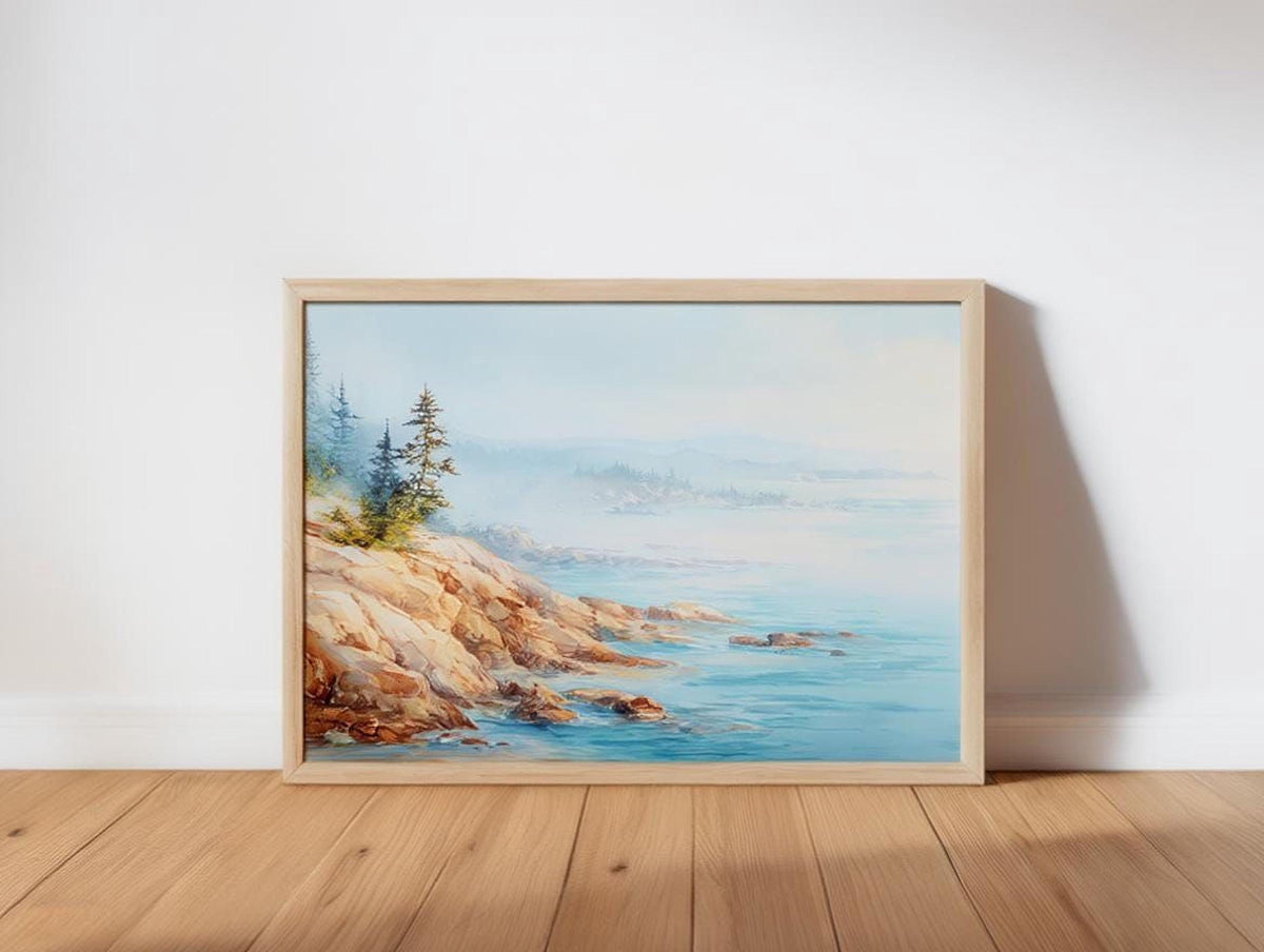 A framed painting depicting a serene landscape with a rocky coastline, trees, and a body of water.