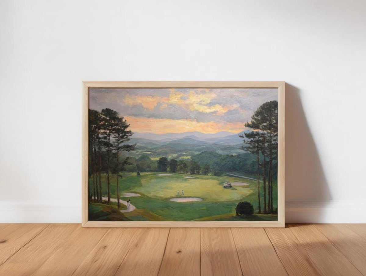 The image is a framed painting depicting a scenic landscape with a golf course, trees, and mountains in the background.