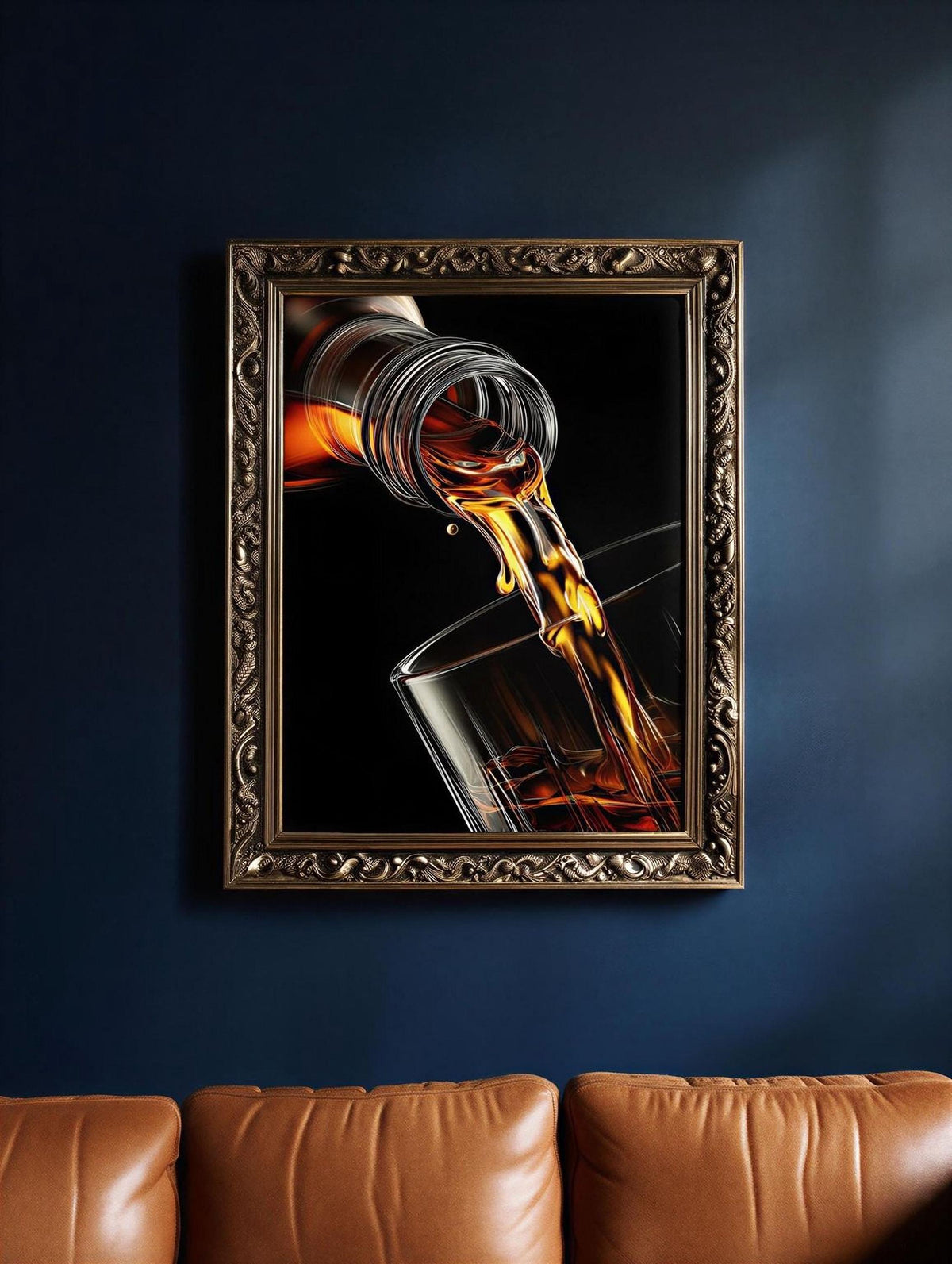 A framed image of a glass of amber-colored liquid, possibly whiskey, being poured into a glass, hanging on a dark blue wall above a leather couch.