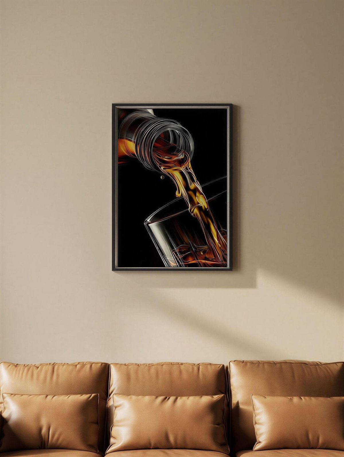 A framed image of a glass of amber liquid, possibly whiskey, with a stream of the liquid flowing out of the glass, hanging on a wall above a brown leather couch.