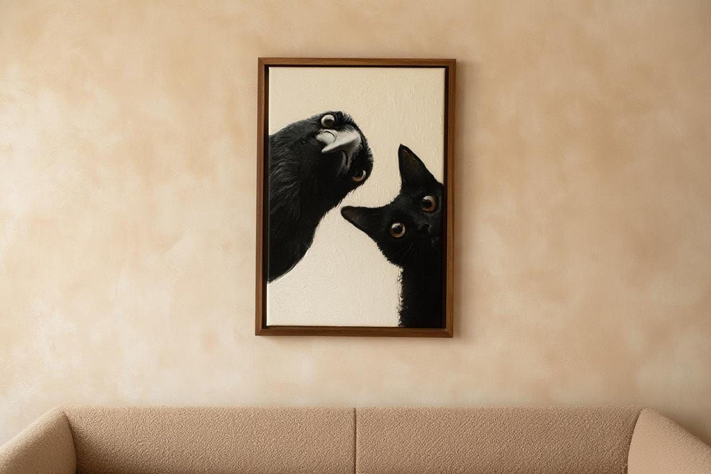 a framed painting of a black cat peeking out from behind a black bird, hanging on a beige wall above a couch.
