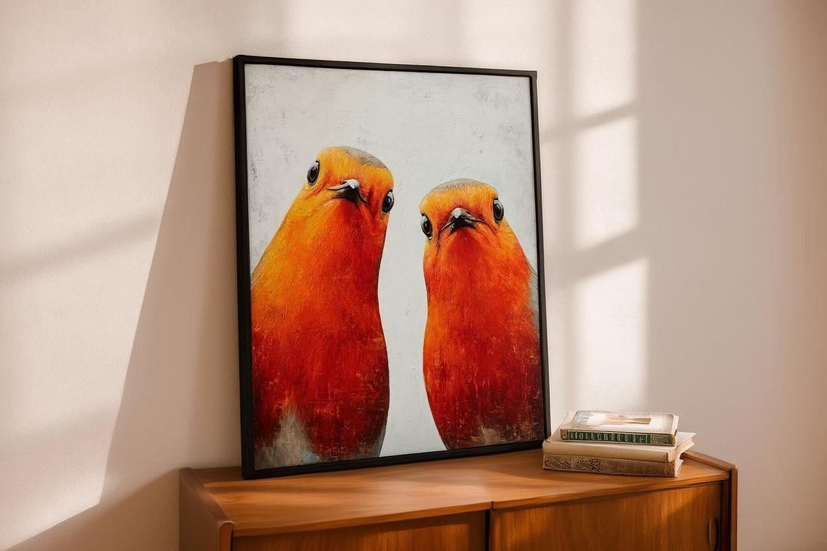 two vibrant red birds with contrasting orange and yellow feathers, standing side by side against a white background.