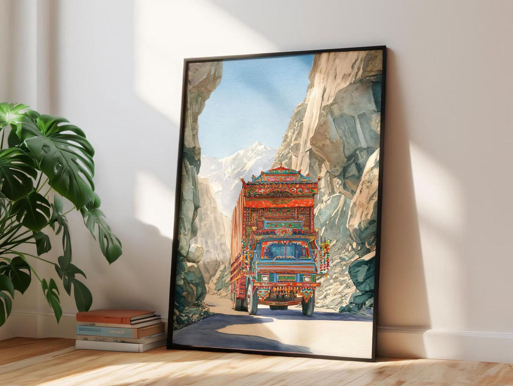 A framed painting depicting a colorful truck driving through a mountainous landscape.