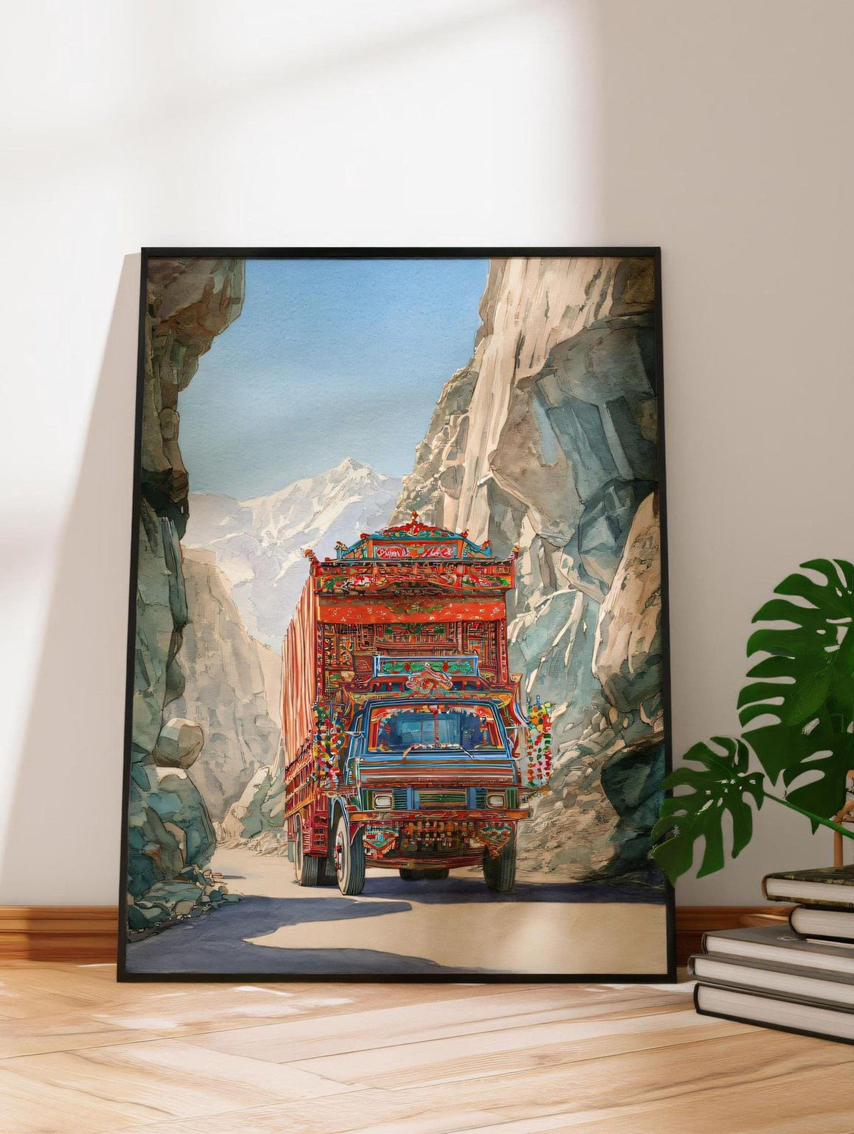 A framed painting depicting a colorful truck driving through a mountainous landscape.