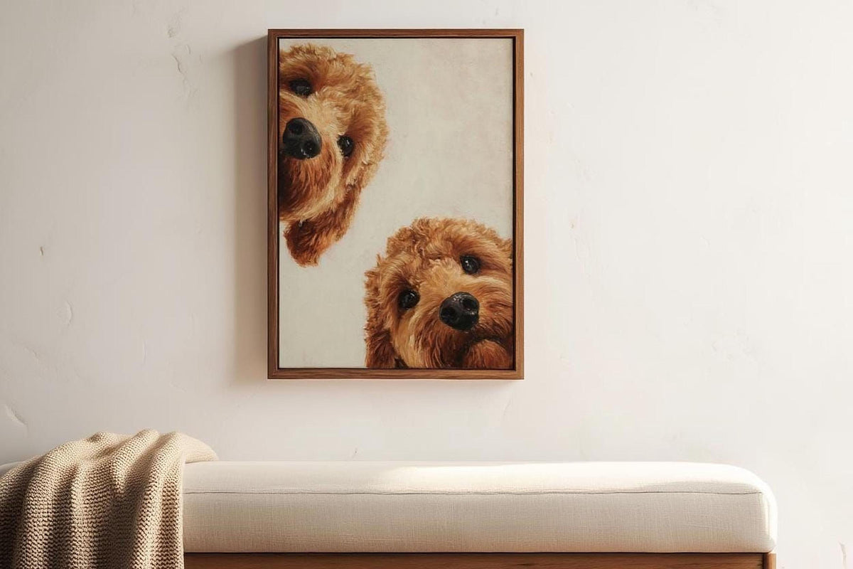 two brown dogs peeking out from behind a wooden frame, hanging on a white wall.