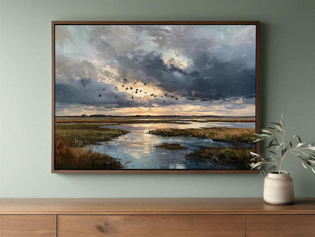 a framed painting of a serene landscape with a river, grassy banks, and a flock of birds flying over the water.