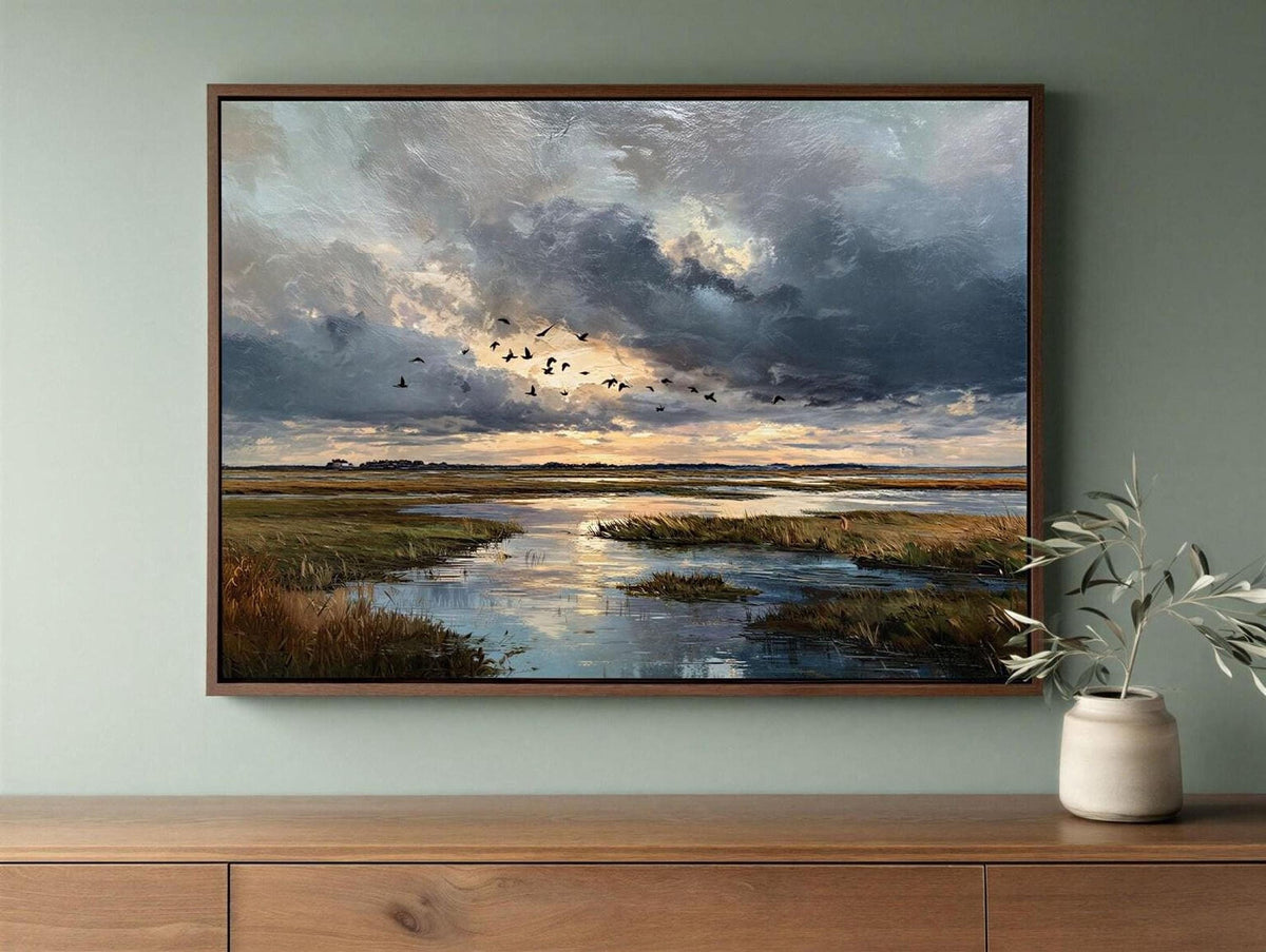 a framed painting of a serene landscape with a river, grassy banks, and a flock of birds flying over the water.
