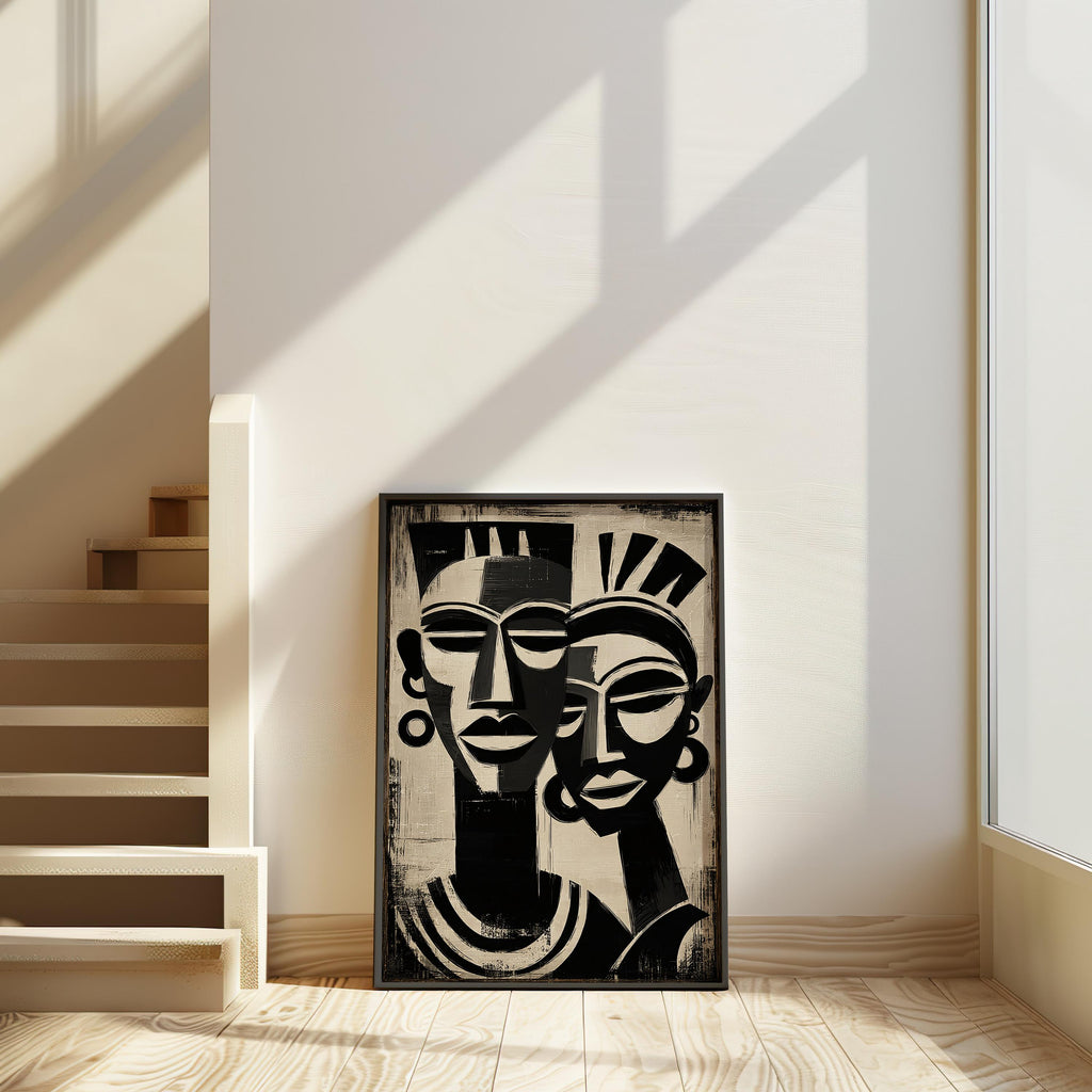a framed artwork of two stylized human faces, placed on a wooden floor in a room with a white wall and a staircase.