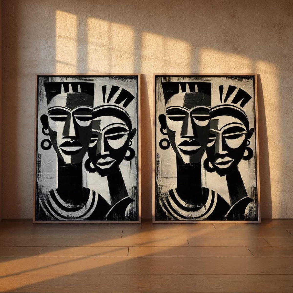two large black and white paintings of abstract human faces, displayed on a wall.