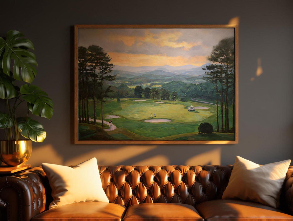 a large painting of a golf course hanging on a wall above a brown leather couch with white pillows.