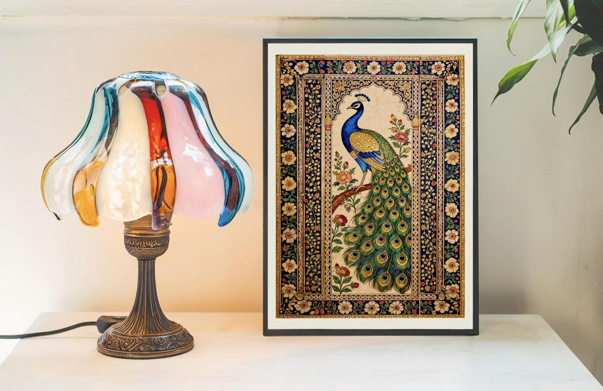 a lamp with a colorful glass shade and a framed picture of a peacock on a table.