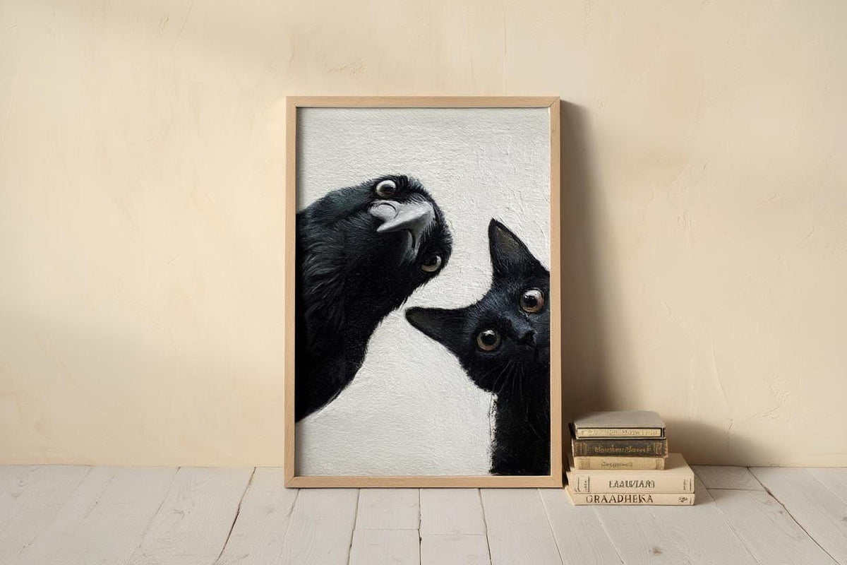 A framed photograph of a black cat peeking out from behind a black bird, with a stack of books next to it on a wooden floor.