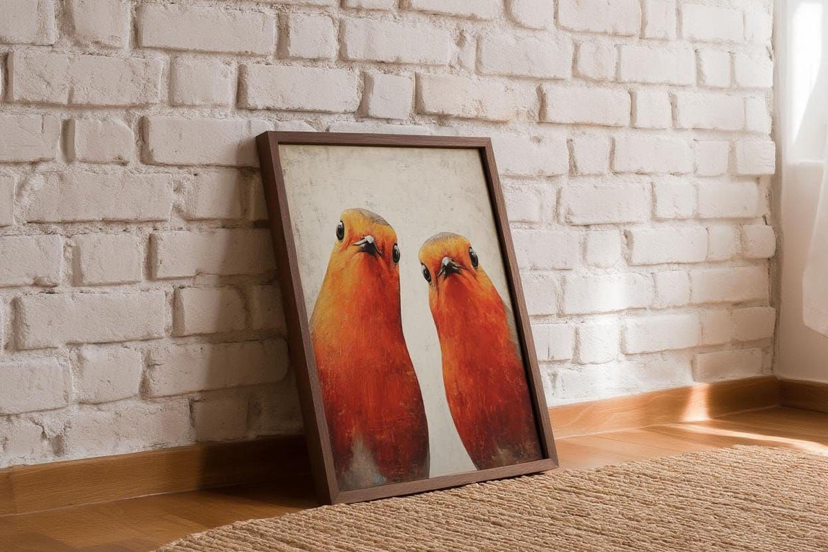 A framed painting of two birds, possibly a parrot, is leaning against a white brick wall.