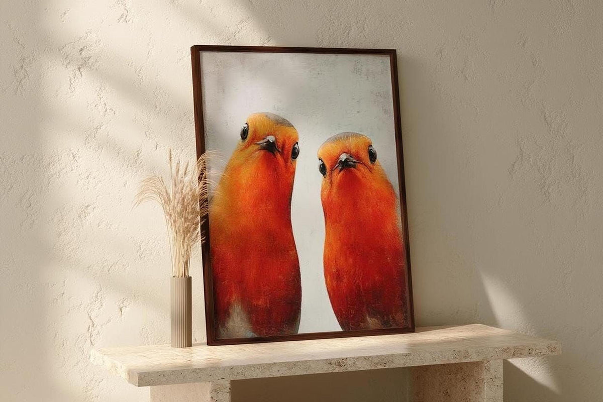two vibrant red birds perched side by side, with a framed photograph of the birds in the foreground.