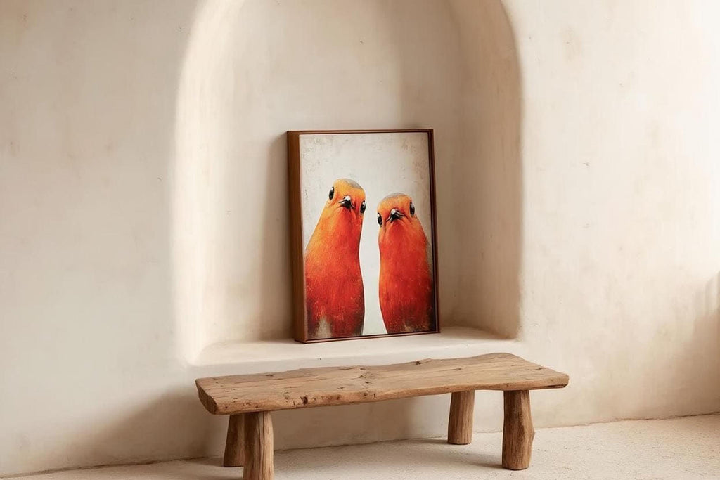 a wooden bench situated in a white alcove, with a framed picture of two birds, possibly parrots, displayed on the wall behind it.