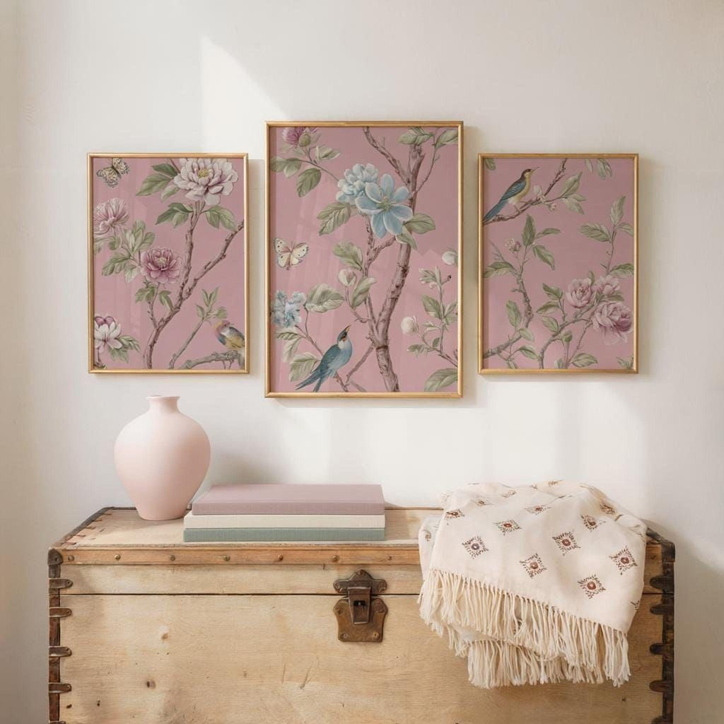 a wooden trunk with three framed floral paintings hanging above it, creating a decorative and harmonious display.