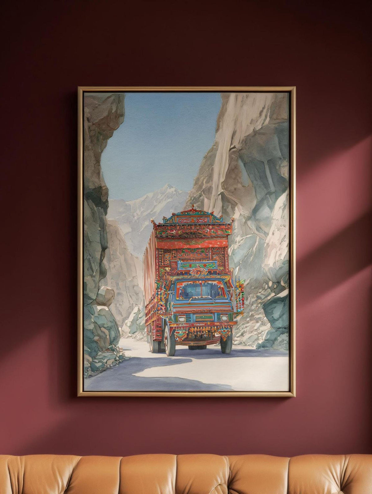 A large, colorful truck is driving down a winding road through a mountainous landscape, with a rocky cliff on one side and a clear blue sky on the other.