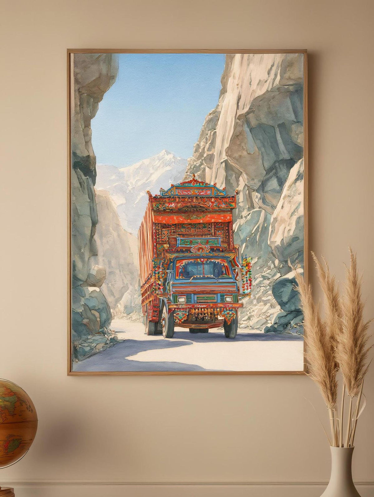 A colorful truck is driving down a road through a mountainous landscape, with a clear blue sky and snow-capped peaks in the background.