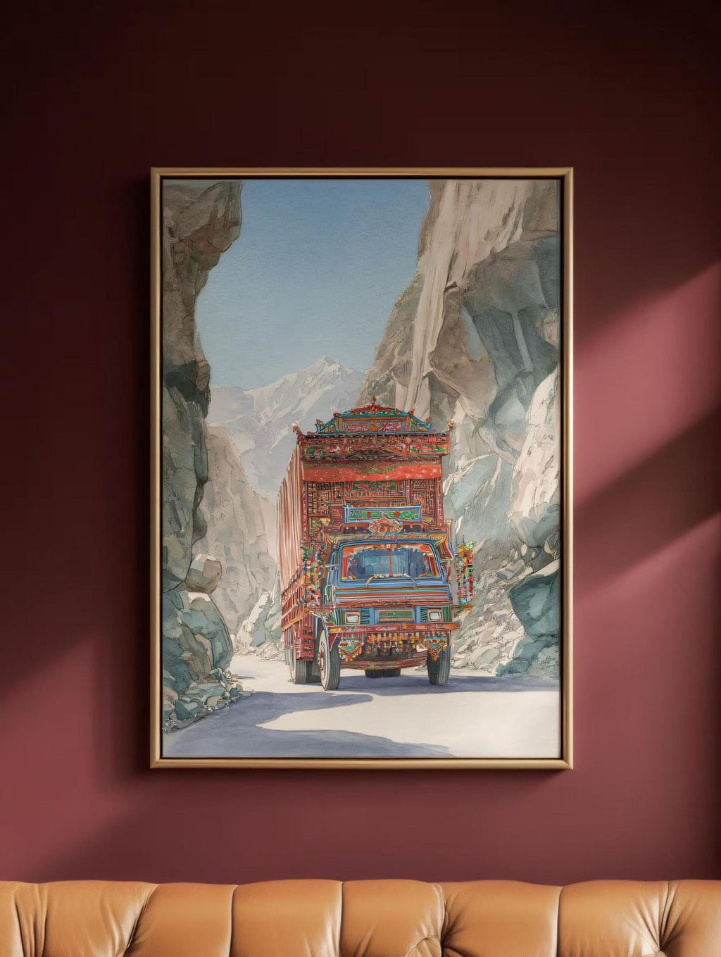 A large, colorful truck is driving down a winding road through a mountainous landscape, with a rocky cliff on one side and a clear blue sky on the other.