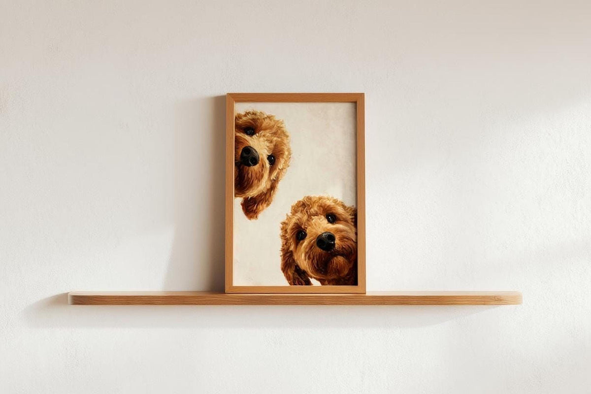 A framed photograph of two brown dogs peeking out from behind a wooden shelf.