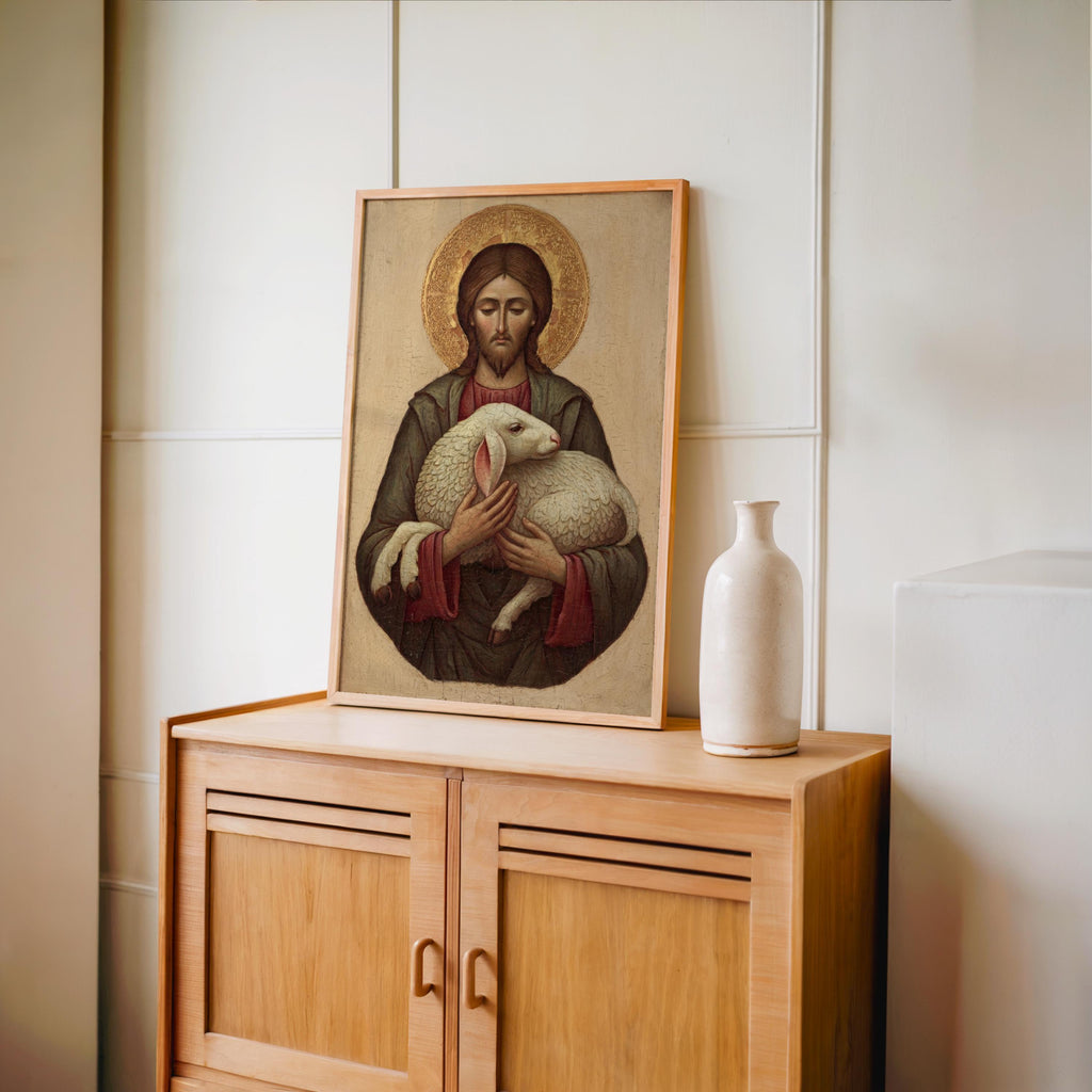a framed painting of Jesus Christ holding a lamb, placed on a wooden cabinet or shelf.