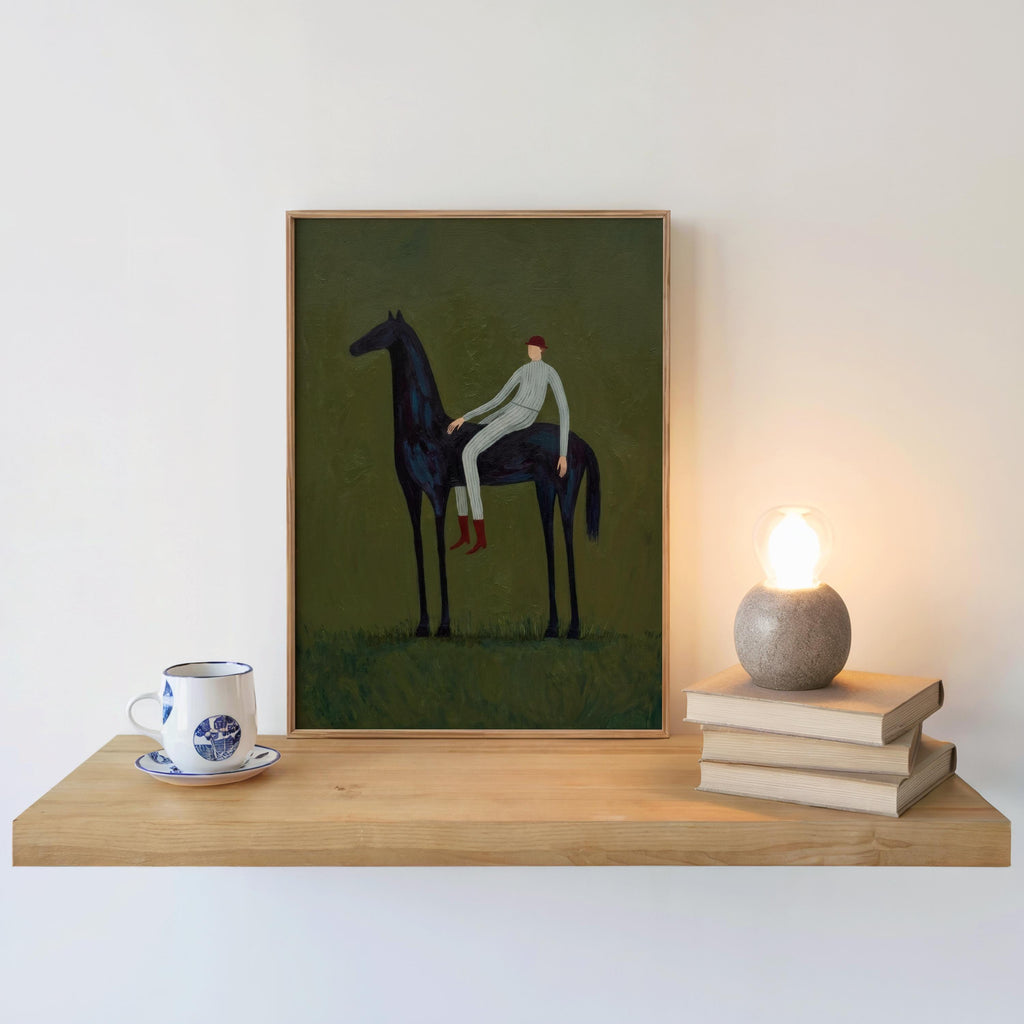 Boho equestrian decor on shelf, framed horse and rider wall art beside books and a warm lamp glow.