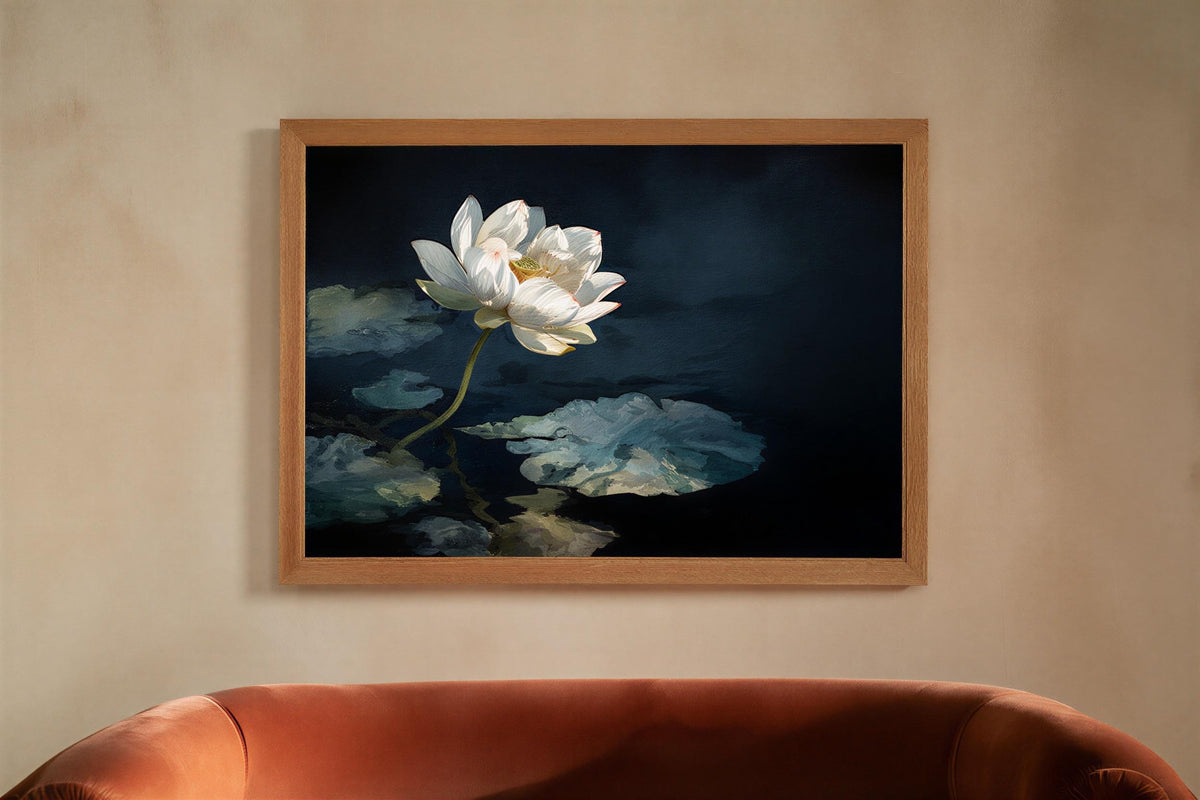 Framed white lotus wall art hung above a leather sofa, deep navy pond and broad leaves create a moody lotus print, zen decor