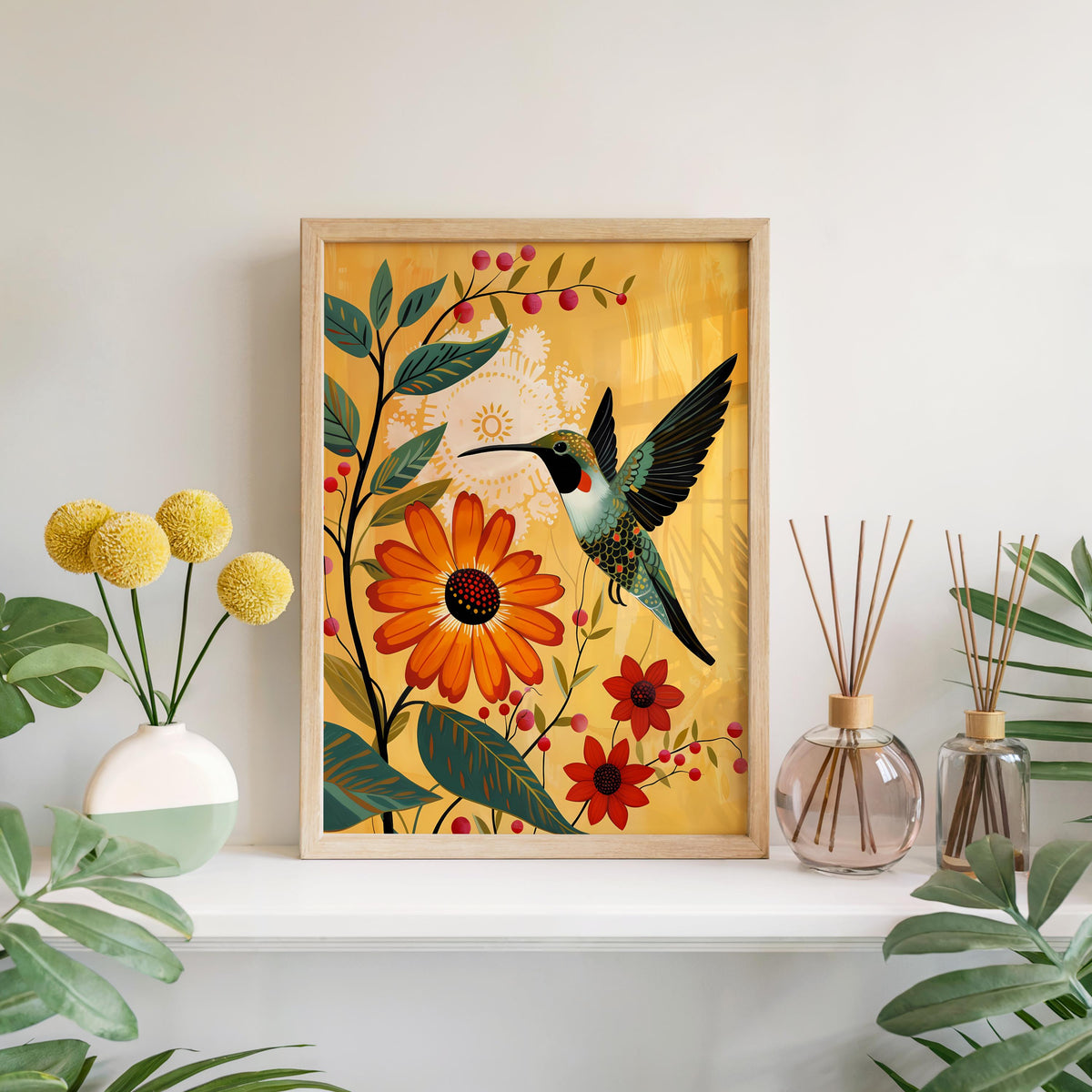 Hanging hummingbird wall art print above shelf with vases and billy buttons, mustard yellow background, orange blooms.