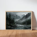 Oak-framed moody mountain landscape wall art leaning on wood floor, misty forest river foreground