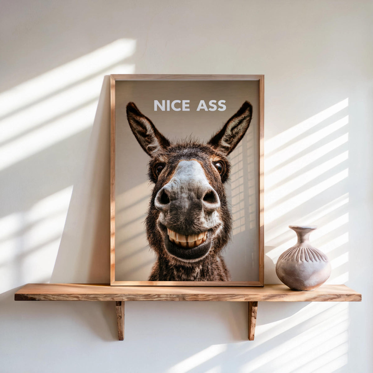 Cream wall setting with framed funny donkey bathroom sign on shelf, smiling donkey, playful downstairs loo print
