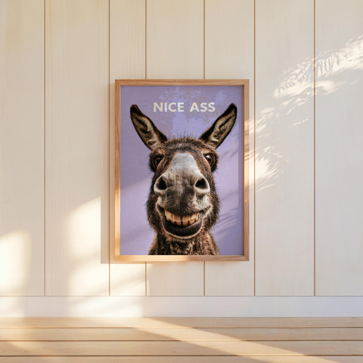 Soft purple funny donkey bathroom sign on paneled wall, bold white NICE ASS text, cheeky restroom decor accent