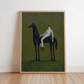 Slim wood-framed horse and rider wall art leaning against wall, dark horse on olive green field.