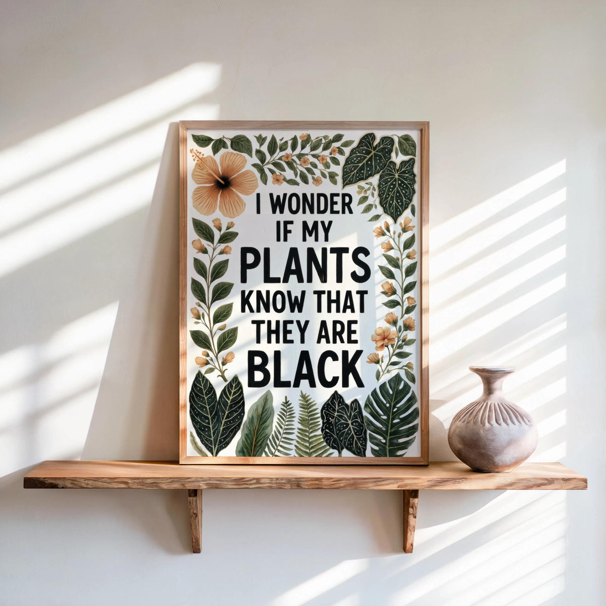 Framed poster on a sunlit wooden shelf, terracotta vase, bold botanicals, black plant lover wall art