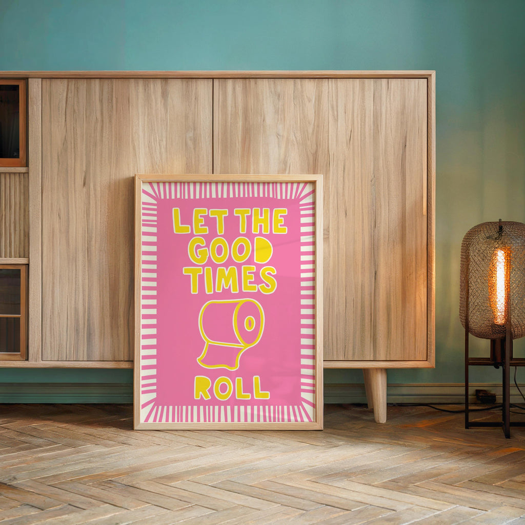 Pink framed print centered by wood cabinet and lamp, funny guest bathroom decor, let the good times roll print