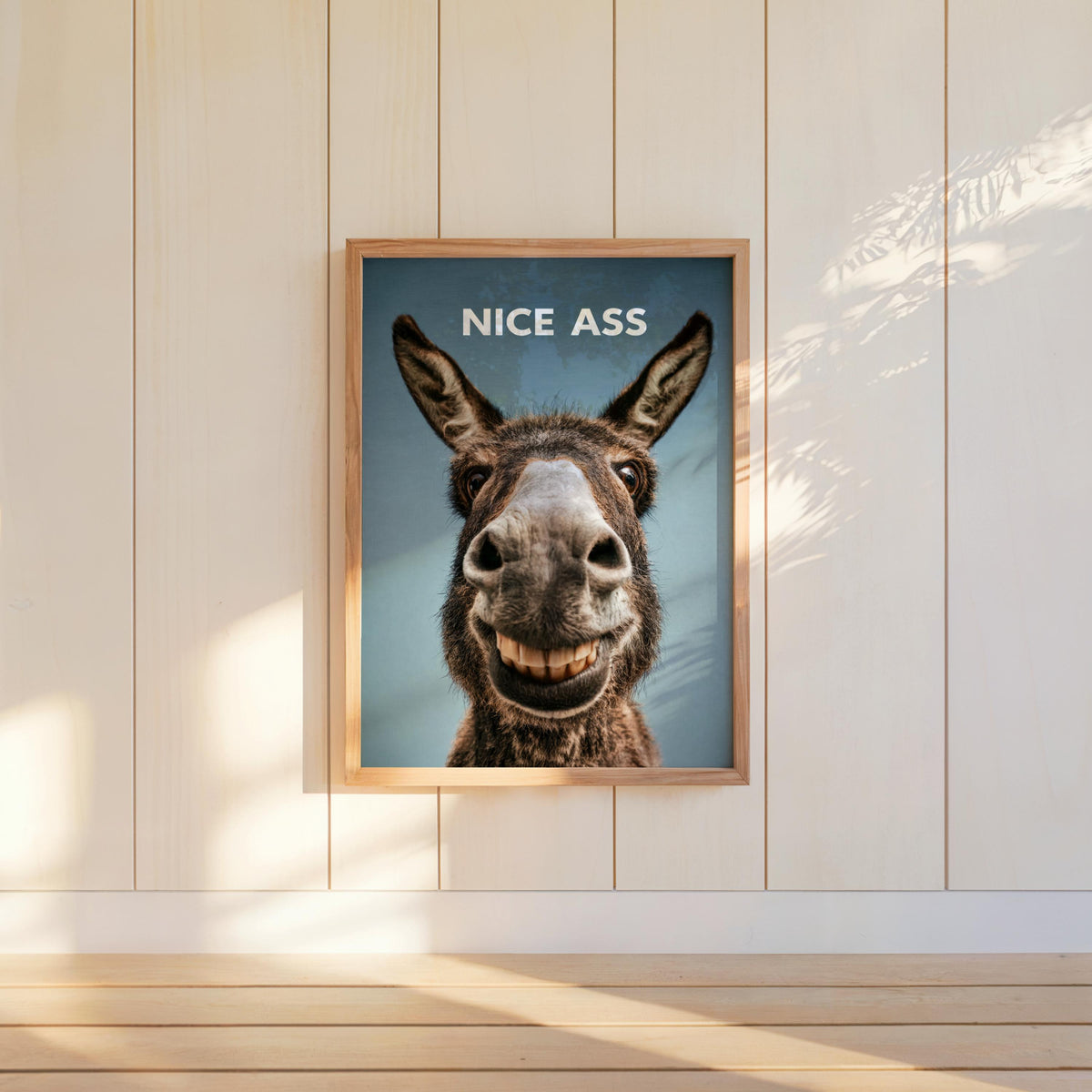 Saturated teal funny donkey bathroom sign centered on white wall, rustic frame, bold NICE ASS message visible