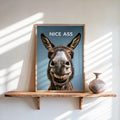 Framed funny donkey bathroom sign on rustic shelf, teal background, smiling donkey, bold NICE ASS text