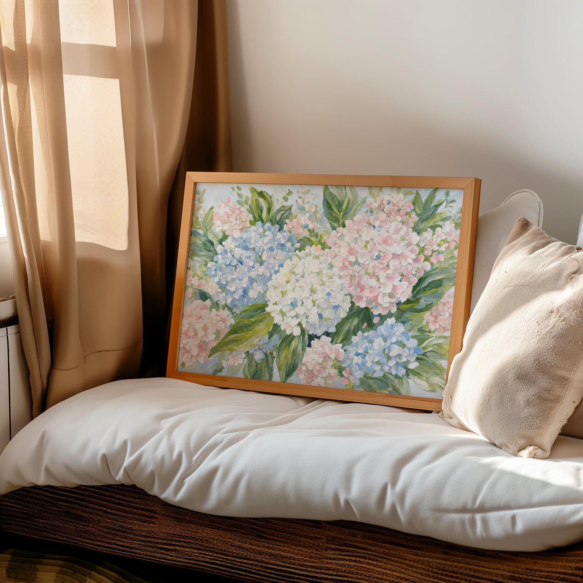 Romantic bedroom scene, pastel hydrangea wall art propped on bed, textured pillows and woven bench