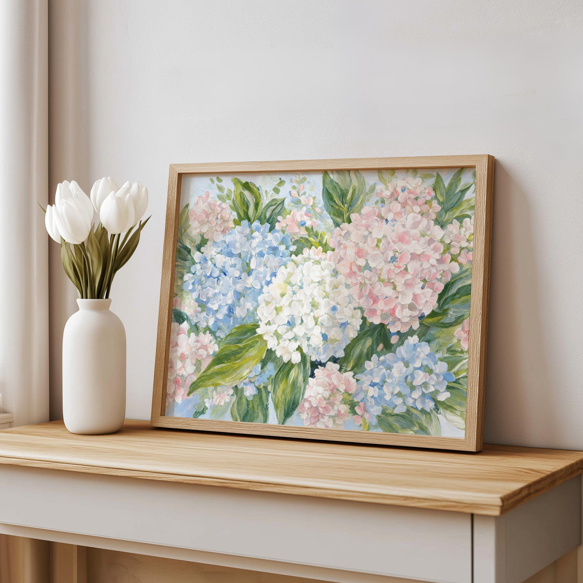 Preppy vignette with framed pastel hydrangea wall art, white tulip vase, clean mantel styling
