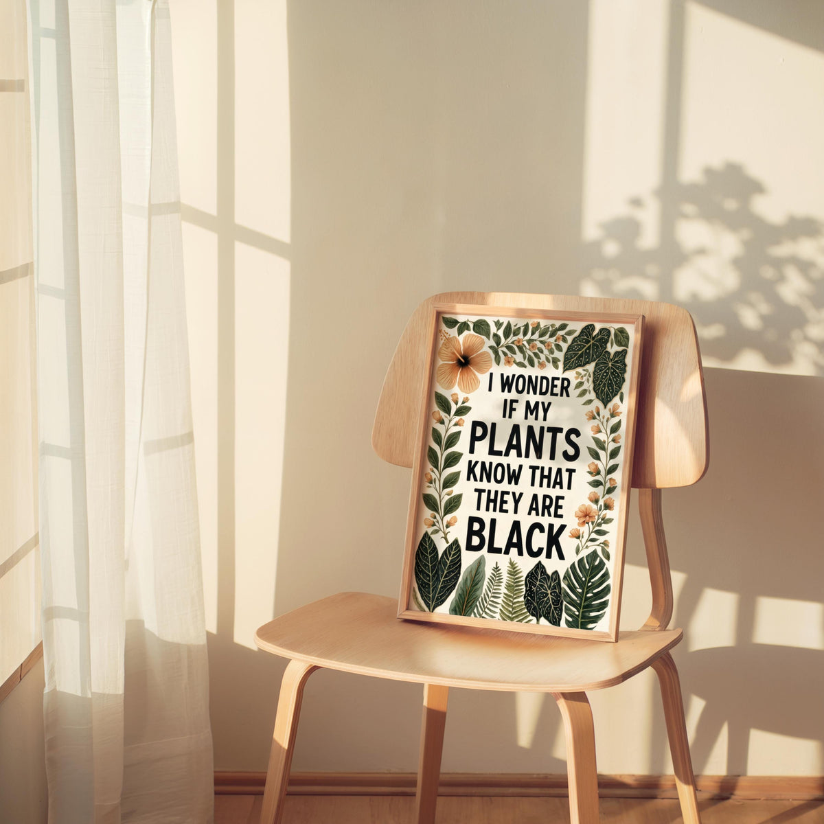 Small wooden chair holds framed typography print, soft shadow, minimal tropical botanical black plant lover wall art