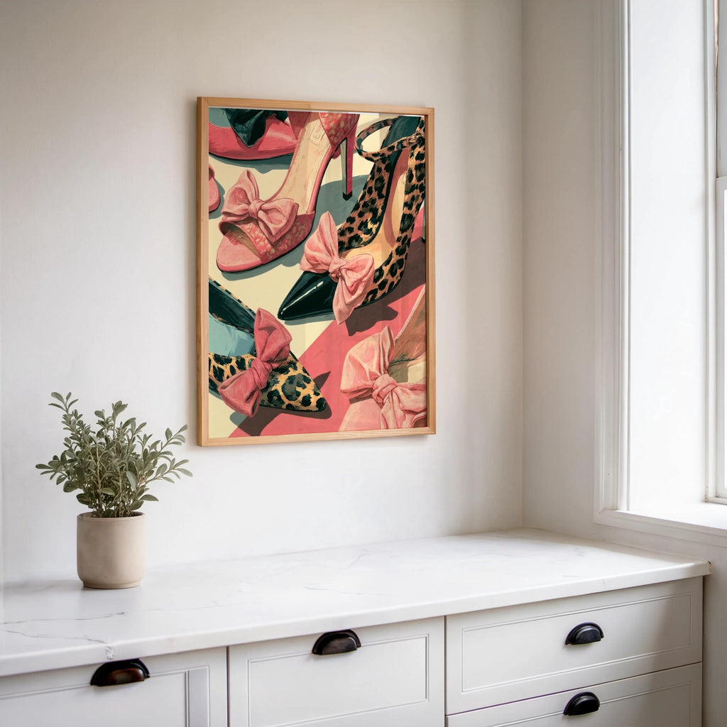 Luxury fashion poster hung above a white console, small plant, coral and green palette, vintage shoe collage