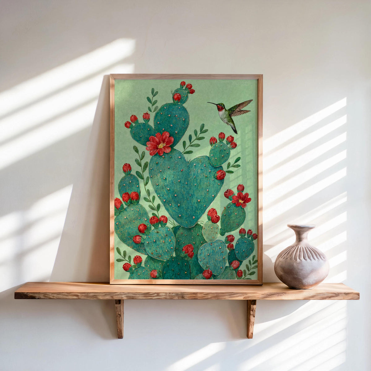 Heart shaped cactus print framed against cool green wall, sun streaks, prickly pear cactus art details