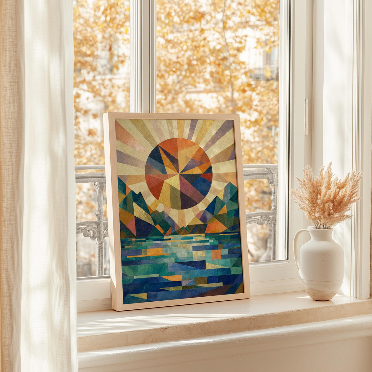 Poster propped in a bright window alcove, color block art print with geometric sunburst and shimmering lake reflections
