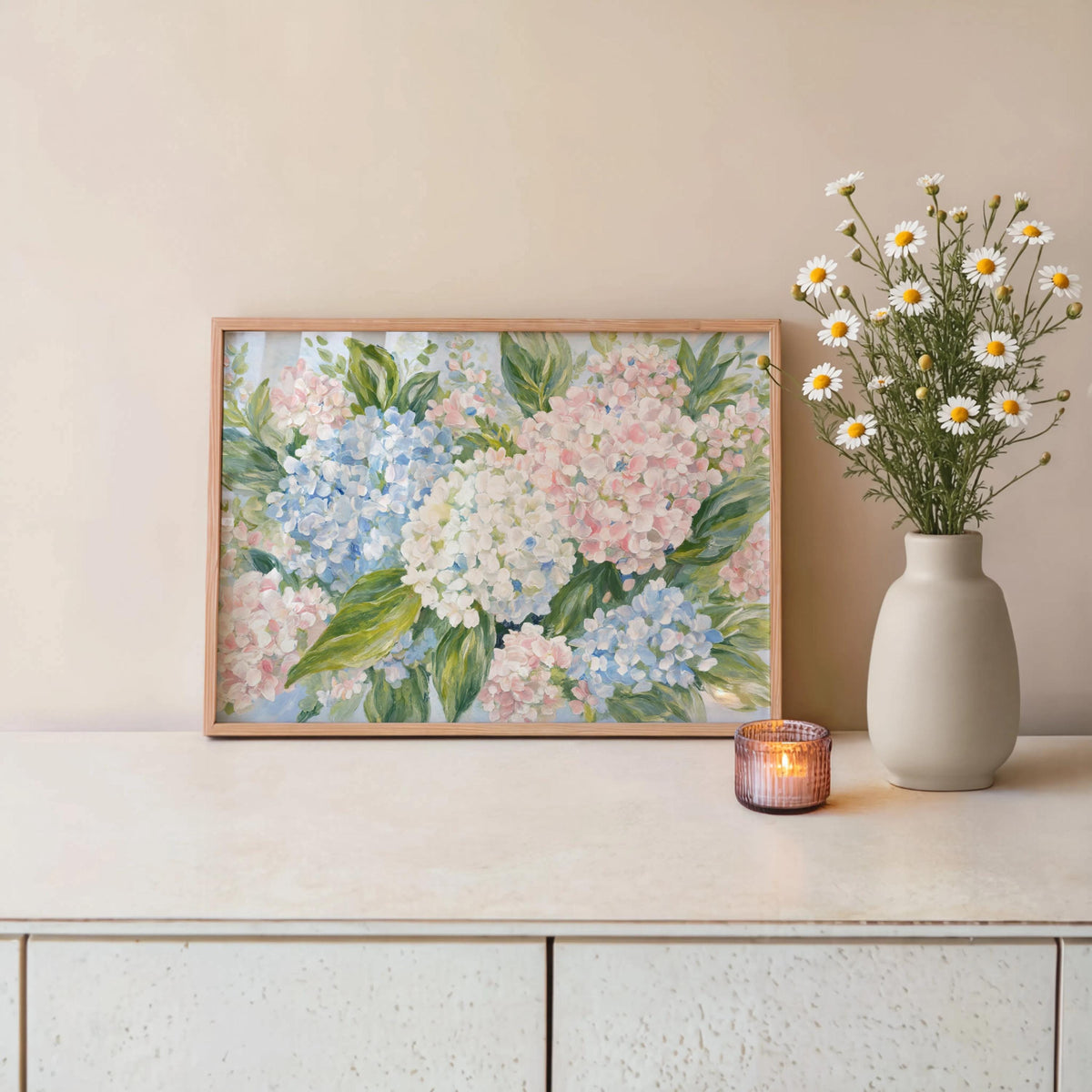 Framed pastel hydrangea wall art on console, vase of daisies and candle, cottagecore botanical styling
