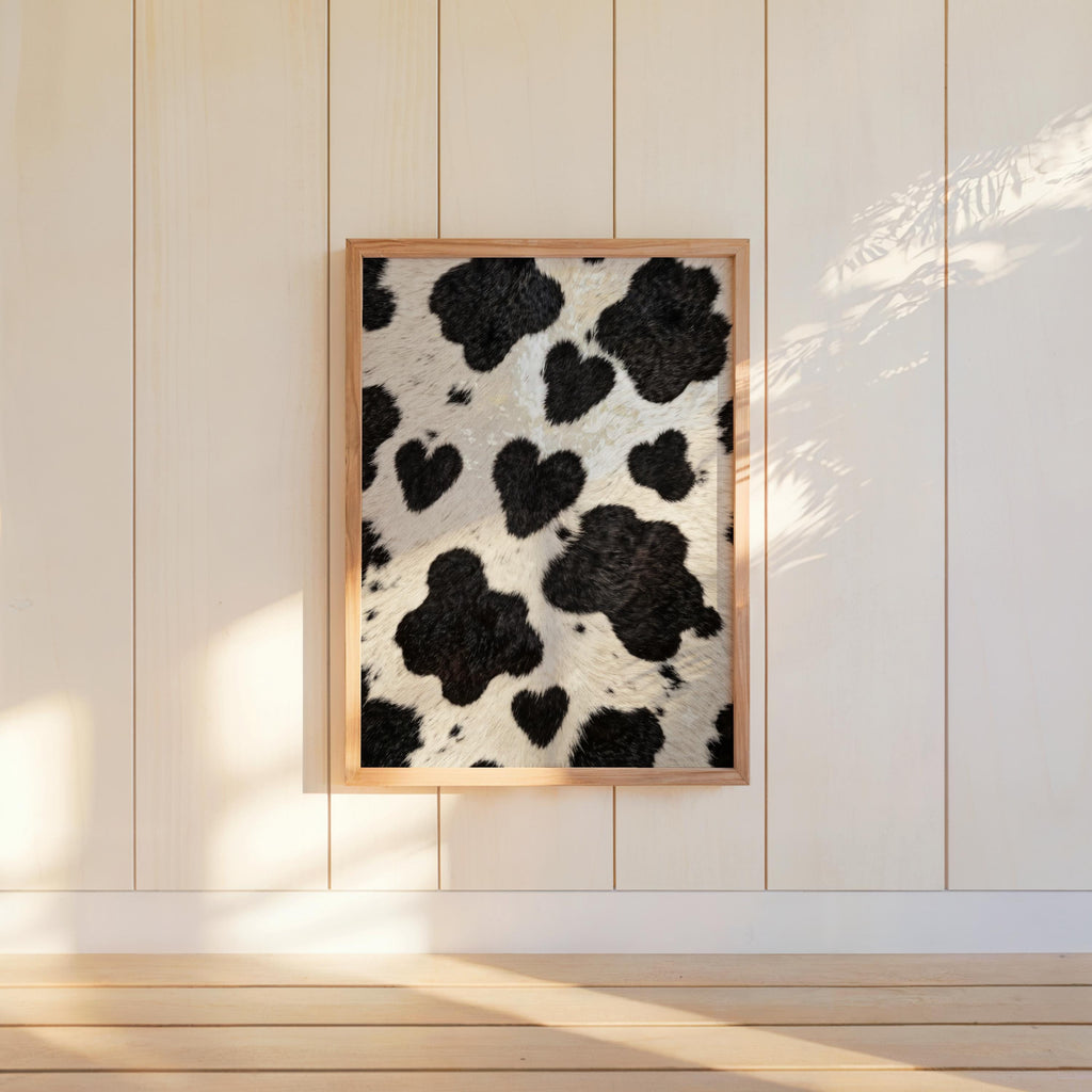 Heart cow print wall art hung on white beadboard, soft sunlight, cozy country wall decor vibe