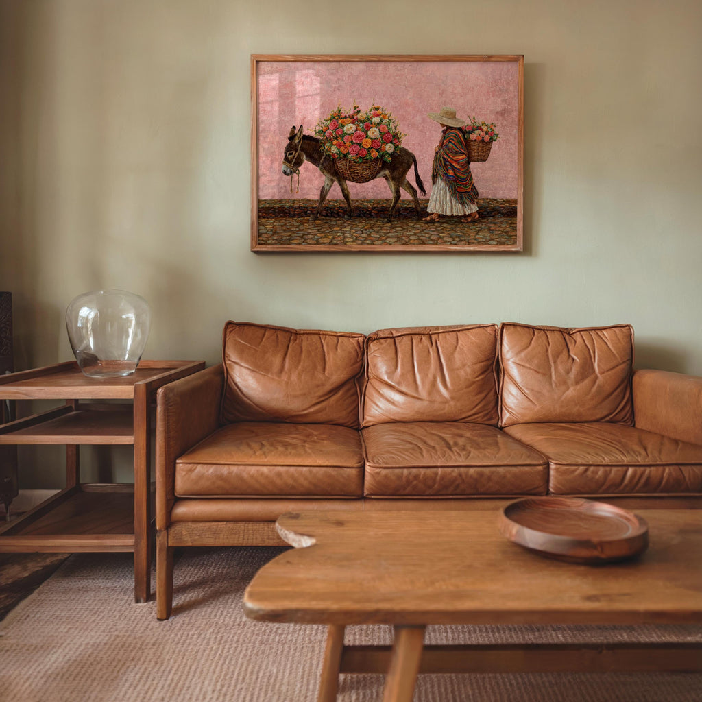 Colorful mexican wall art hung above leather sofa, pink distressed sky, market scene brings mexican boho wall decor energy