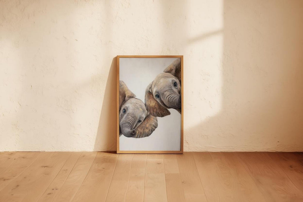 Framed peeking elephant art resting on floor near wall, neutral jungle animal nursery print, gentle sunlight