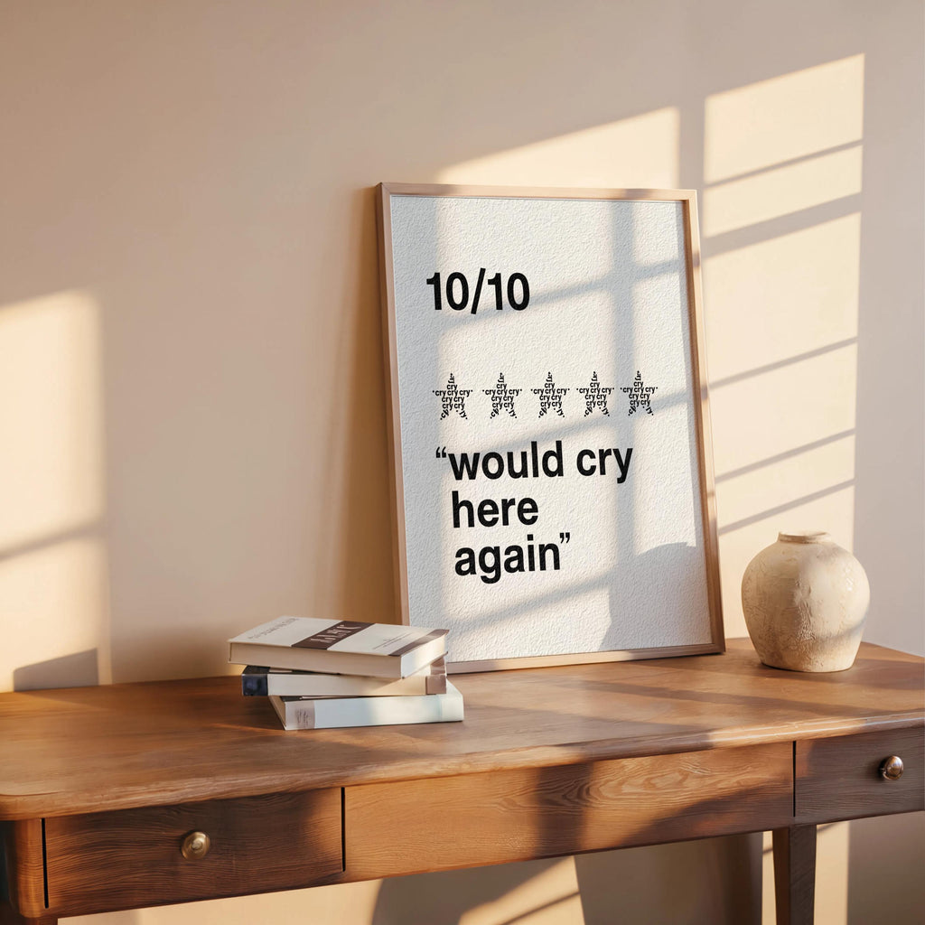 Cream would cry here again print beside books and clay vase, soft light, subtle retro texture, funny therapy wall art option
