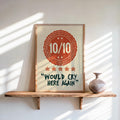 Leaning would cry here again print in warm orange on a floating shelf, sunlit wall, ceramic vase