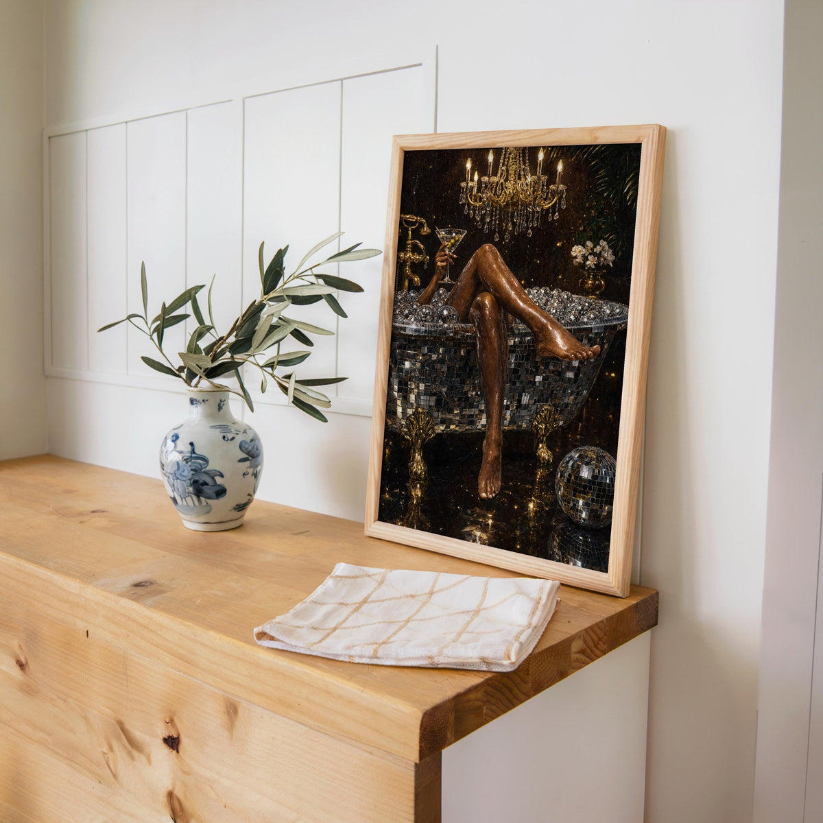 Disco bathtub print framed and resting on a wooden desk with a vase and open book, martini bathroom art and retro glam mood